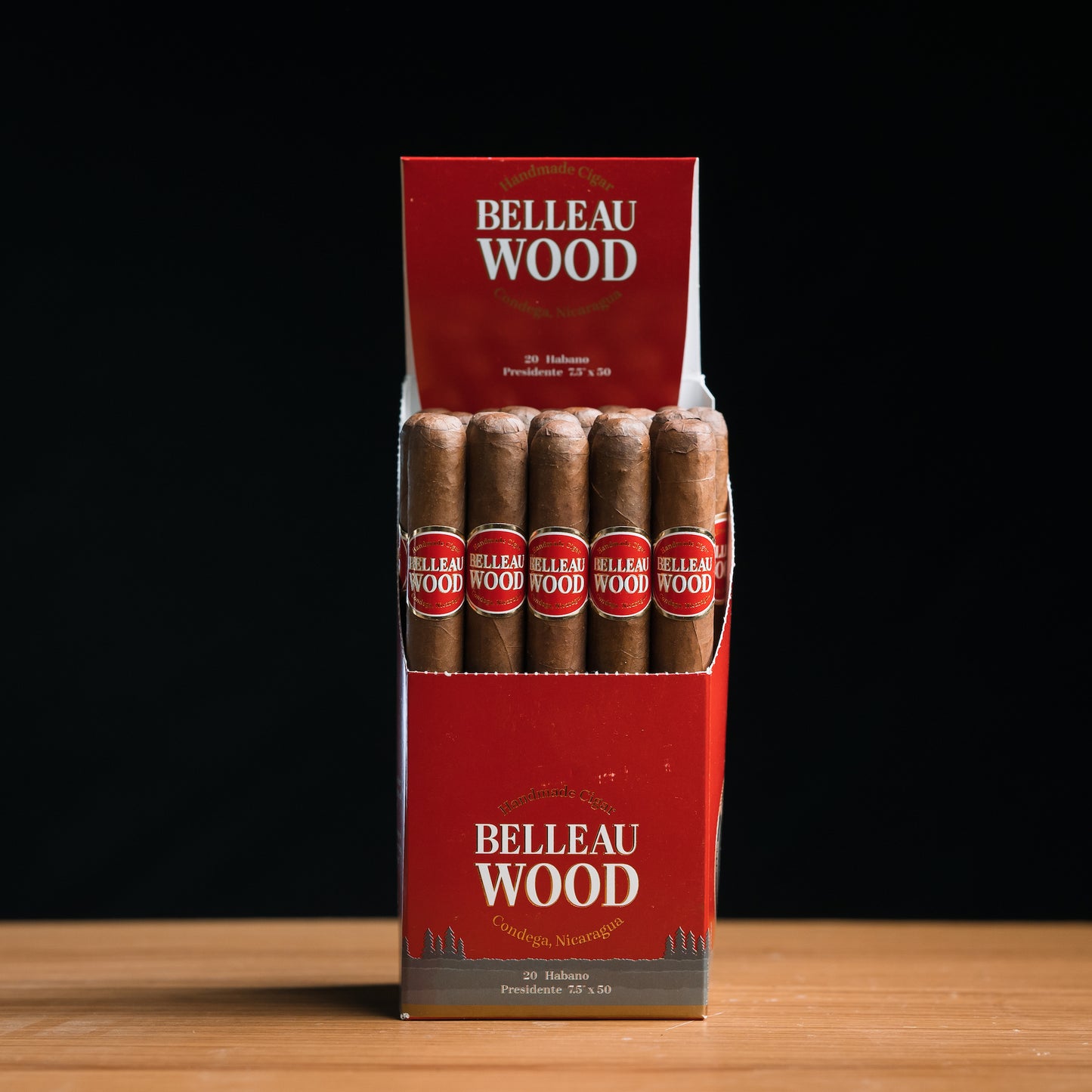 A box of Belleau Wood Habano Presidente cigars, with individual cigars visible inside the box. The box is red with the brand name prominently displayed.