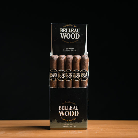 A box of Belleau Wood Maduro Presidente cigars with several cigars visible, set against a dark background.