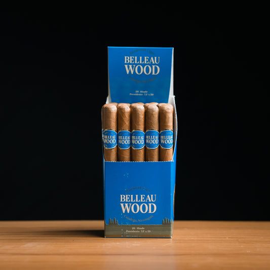 A box of Belleau Wood Shade Presidente cigars, with individual cigars visible inside the box. The box is predominantly blue with gold text and accents.